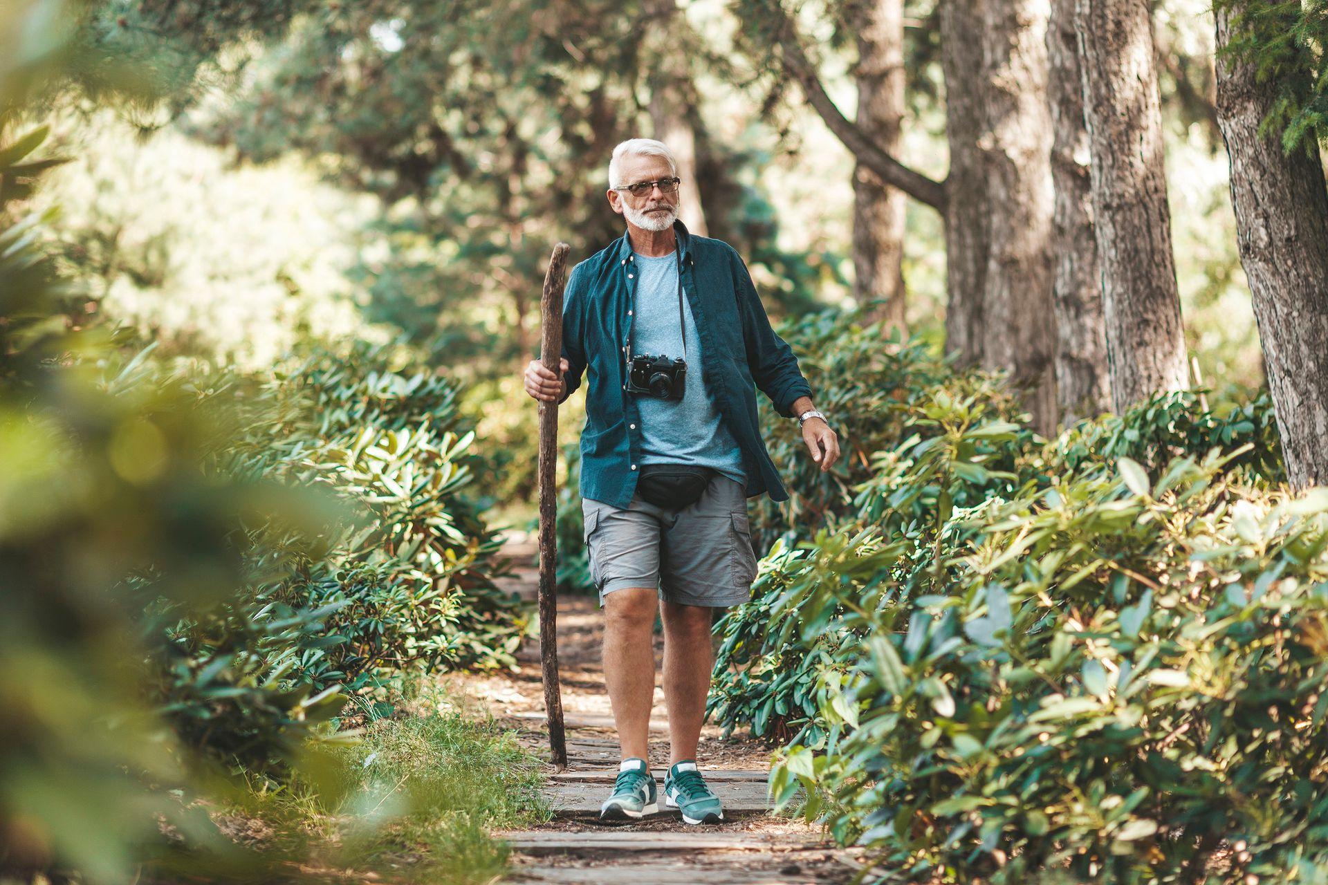 Man die bijdraagt aan zijn vitaliteit door te wandelen door het bos